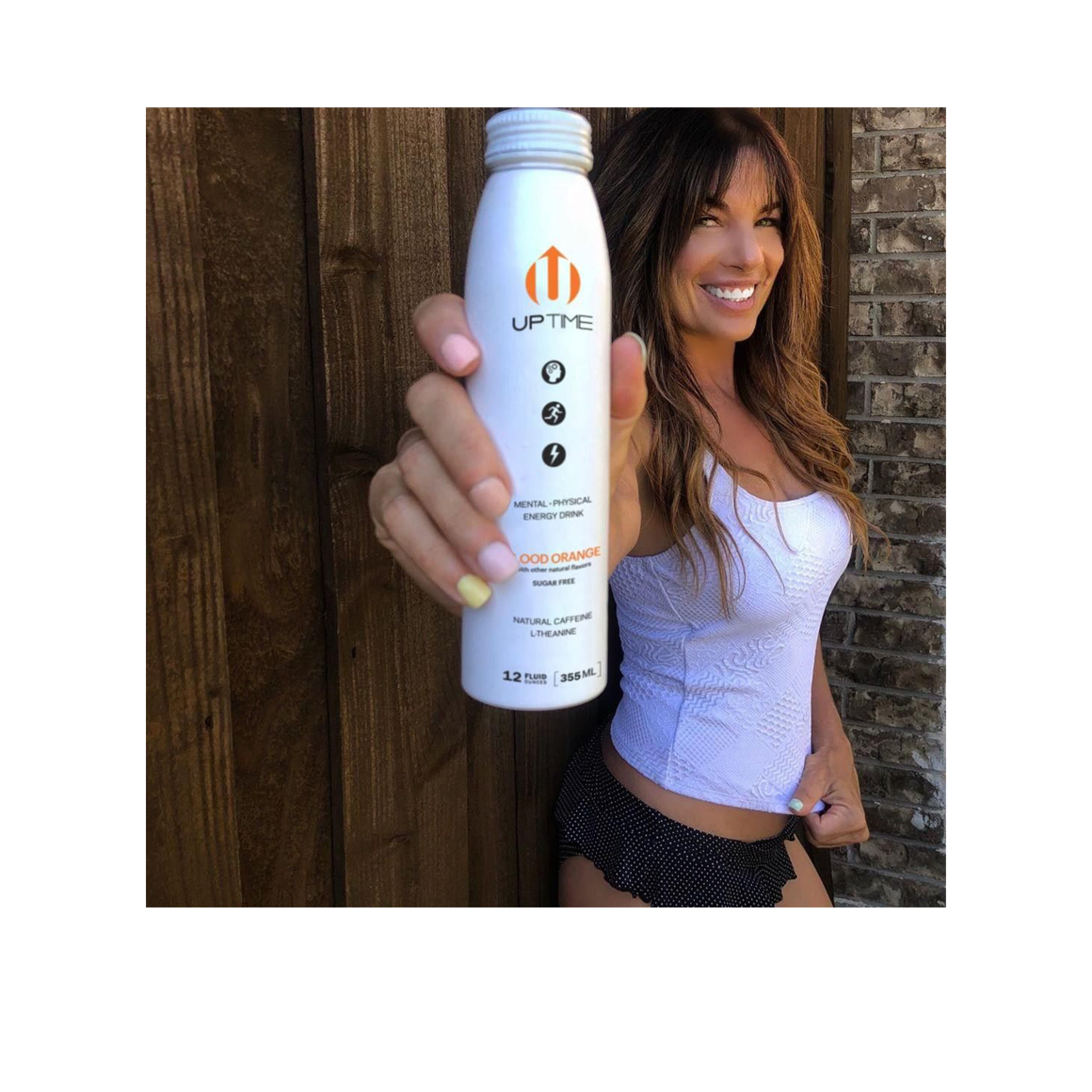 woman holding a bottle of uptime blood orange energy drink Image2