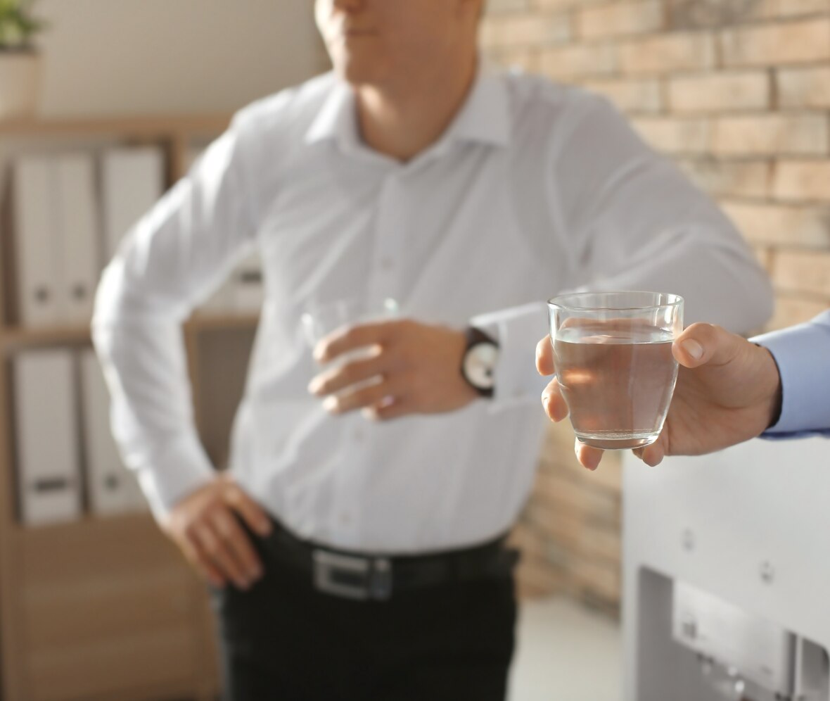 two men drinking water in an office