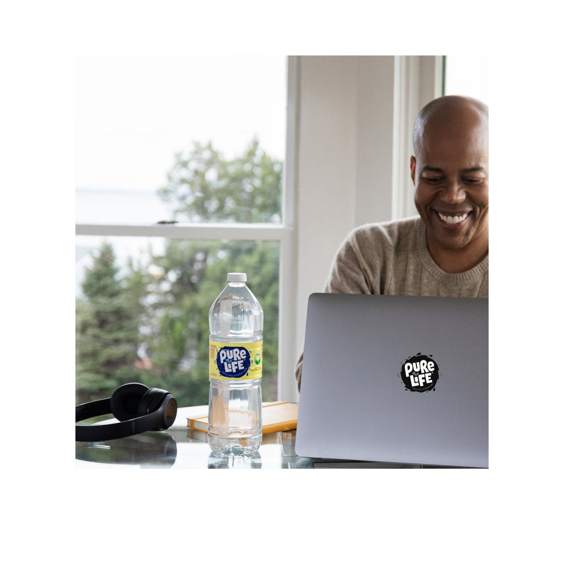 man using laptop with pure life bottled water Image5